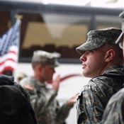 U.S. military service members standing near an American flag